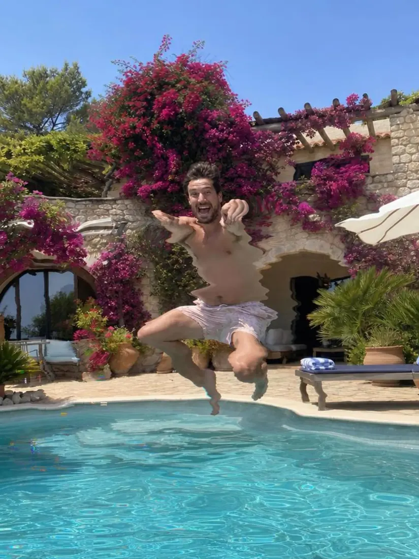 A shirtless man in swim shorts jumps at a pool with a wavy, distorted torso, before the Distortion Remover repairs the image.