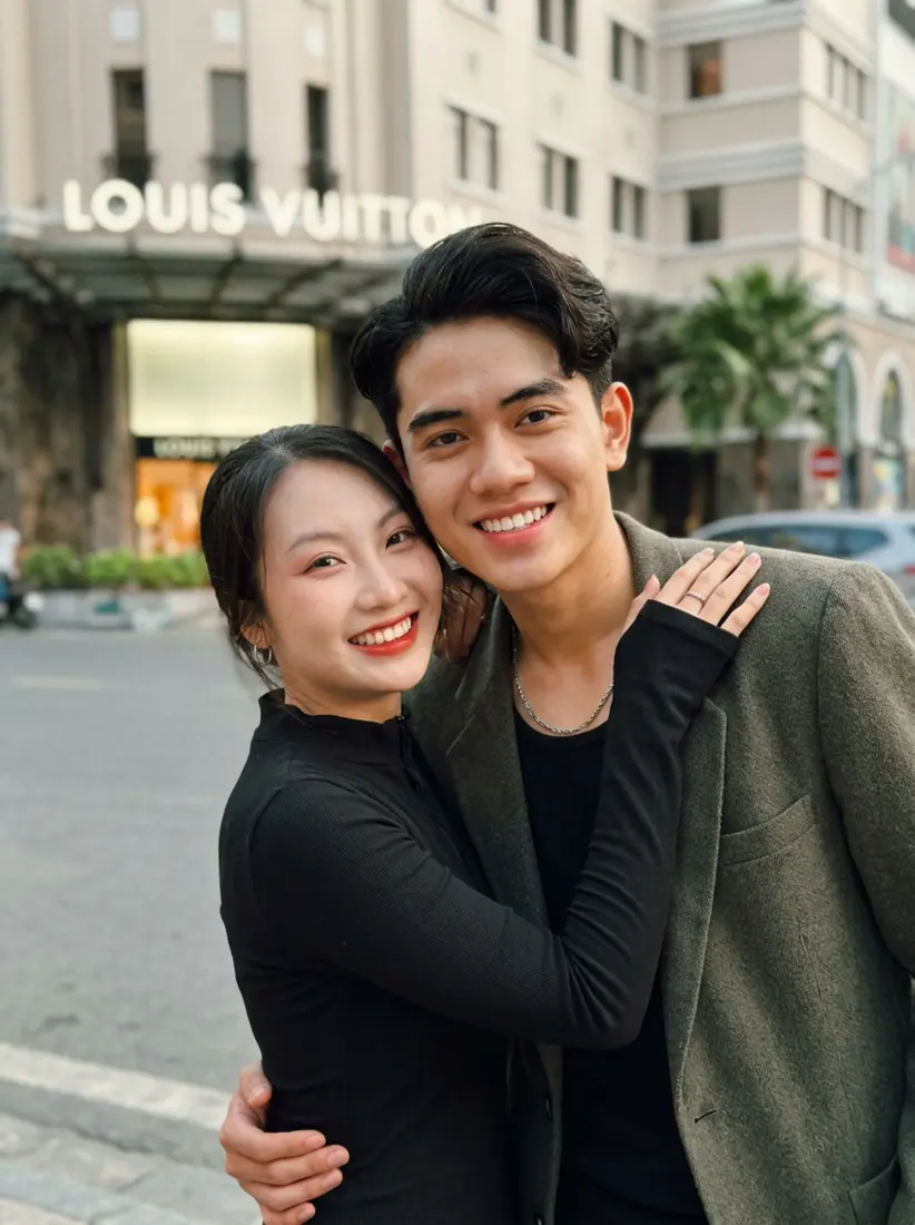 A couple stand on a city street in front of a Louis Vuitton store, before the Future Baby Generator creates a child portrait.