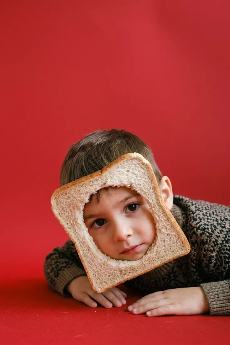 A young boy peeks through a bread-shaped photo frame, a human version created by the Pet to Human Filter tool.