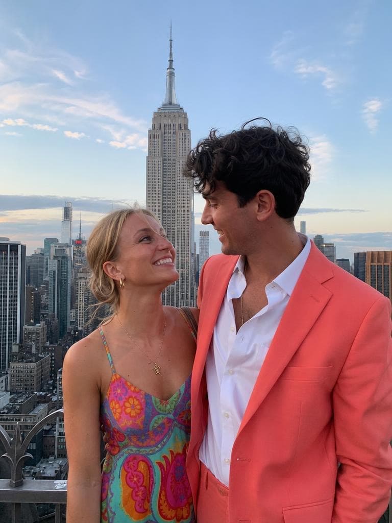 A couple poses on a New York rooftop by the Empire State Building, before the Snow Globe Generator shrinks the scene.