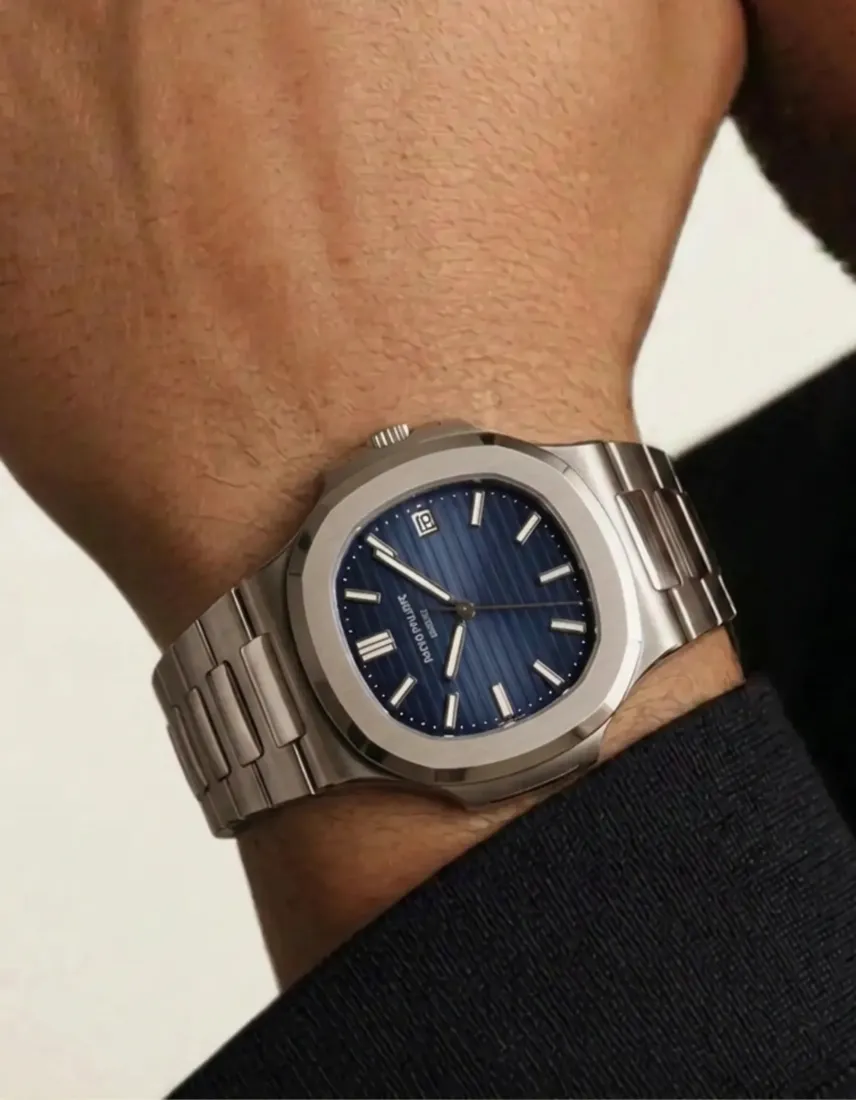 A close-up wrist wears a steel watch with a blue dial, generated by the Watch Generator tool.
